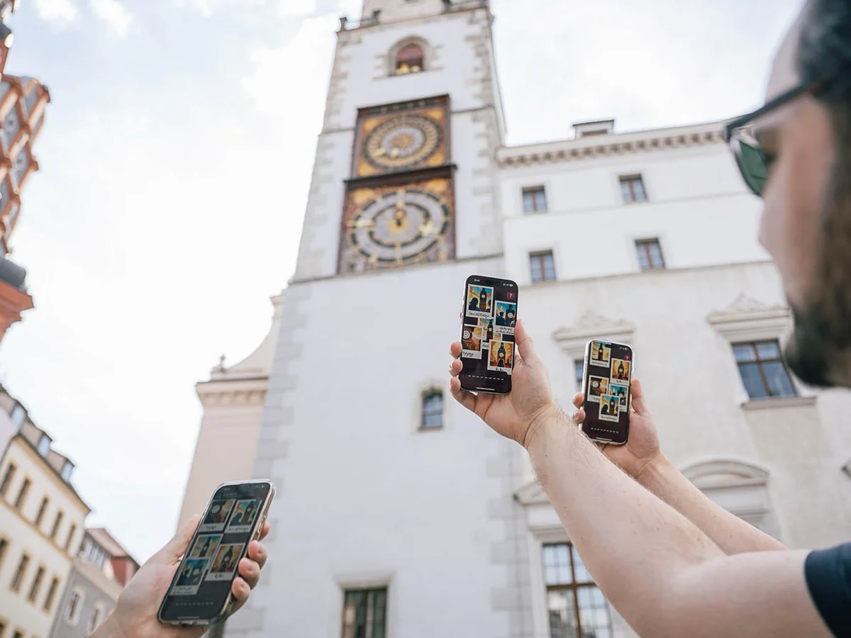 Gruppe spielt eine Handy-Schnitzeljagd mit Smartphone und Schatzkarte.