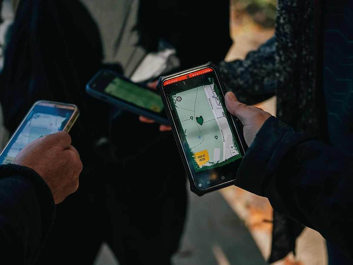 Gruppe spielt eine Handy-Schnitzeljagd als Team-Event.
